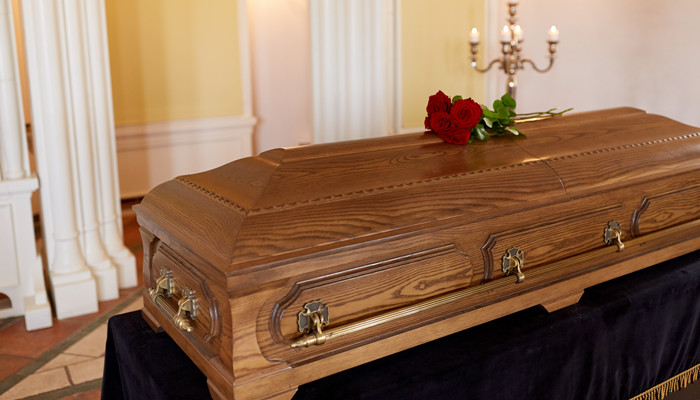 摄图网_300428914_葬礼哀悼教堂木制棺材上的红玫瑰花教堂木制棺材上的红玫瑰花（企业商用）.jpg